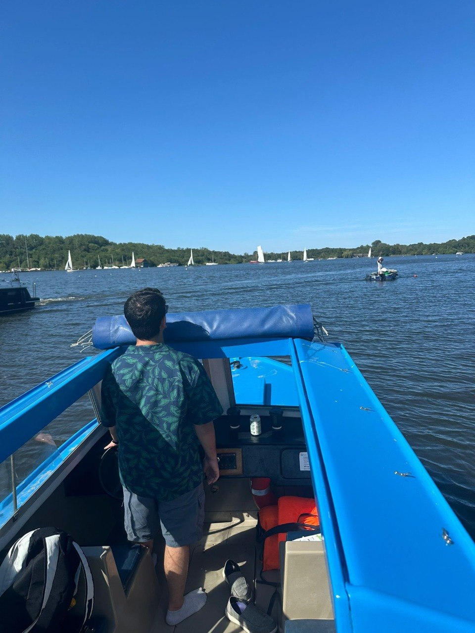 Shub at the helm of a boat on a lake