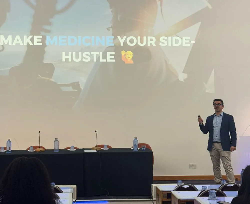 Shub speaking on stage to clinicians about building beyond medicine